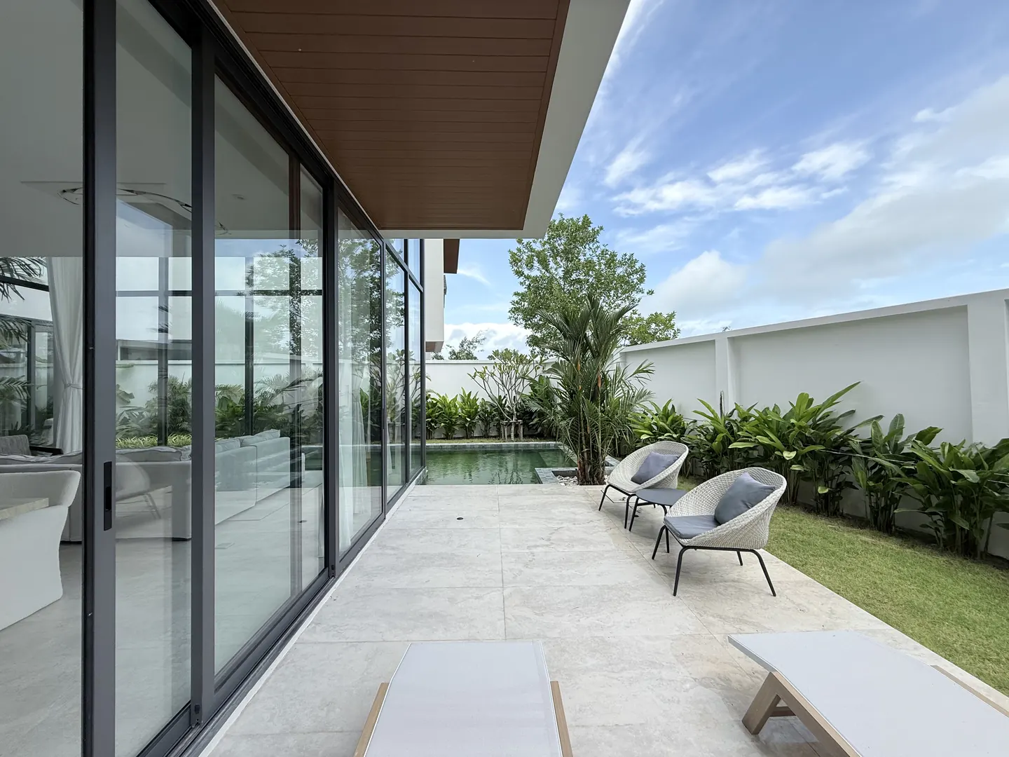 Covered terrace with lounge chairs facing the garden